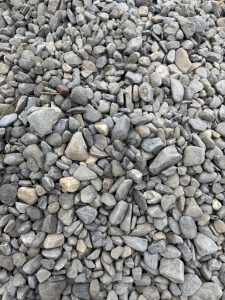 A close-up view of a pile of small, smooth gravel stones in various shades of gray.