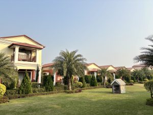 A scenic view of a well-kept landscaping area featuring several modern homes with red-tiled roofs and balconies
