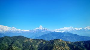 A beautiful panoramic view of the snow-capped Machhapuchhre (Fishtail Himal) under a clear blue sky.