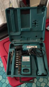 An open case with a drill and all its pieces inside.
