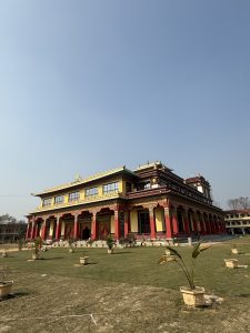 A colorful red and yellow temple with ornate decorations and large windows.