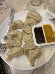 
A white plate filled with freshly steamed dumplings arranged in a circular pattern.