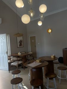 A modern, cozy interior featuring several wooden tables and chairs. 