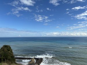A wide view of the ocean under a bright blue sky with white clouds in Isumi, Chiba.