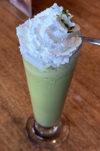 Creamy matcha delight topped with fresh whipped cream.