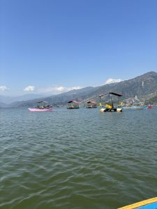 
A serene lake scene featuring several colorful boats floating on the water.