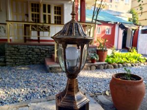 
A decorative outdoor lantern stands in the foreground, showcasing a glass cover and a vintage design.