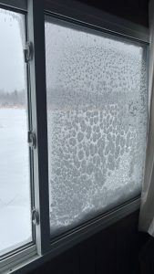A window with the screen encrusted with snow and ice.
