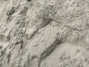 Close-up of a textured sand dune with visible ridges and layers.