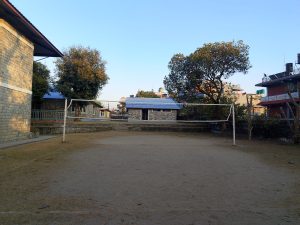 A sandy outdoor volleyball court is visible in a quiet setting.