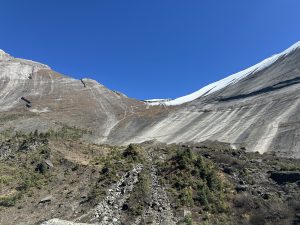 A panoramic view of a rugged mountainous landscape under a clear blue sky at Manang Nepal.
