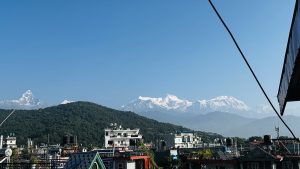 A scenic view of snow-capped mountains in the background, prominently featuring peaks against a clear blue sky.
