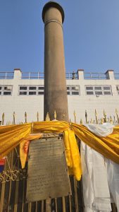Standing tall in the blue sky featuring an inscription in Pali confirming Lumbini as Buddha's birthplace.