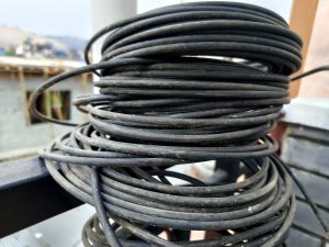 
A tangled pile of black electrical wire coiled neatly. 