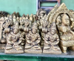 A cluster of small bronze statues depicting a seated figure with a headdress, holding a trident and making a gesture of reverence.