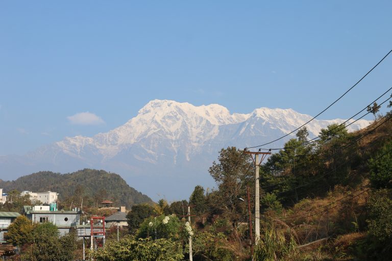 A clear blue sky serves as the backdrop for majestic snow-capped mountains in the distance.