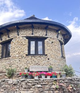 
A round, stone-built structure featuring large windows at the top. 