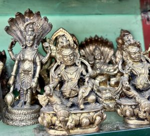 
A collection of intricately designed metallic statues, featuring various deities from Eastern religious traditions.