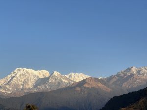 
A panoramic view of majestic snow-capped mountains under a clear blue sky.
