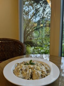 A plate of creamy spaghetti on a wooden table.