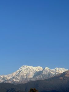 A panoramic view of majestic snow-capped mountains under a clear blue sky. 