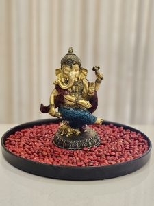 A decorative Ganesha statue set on red lucky seeds in Perumanna, Kozhikode, is beautifully detailed and well-composed. 