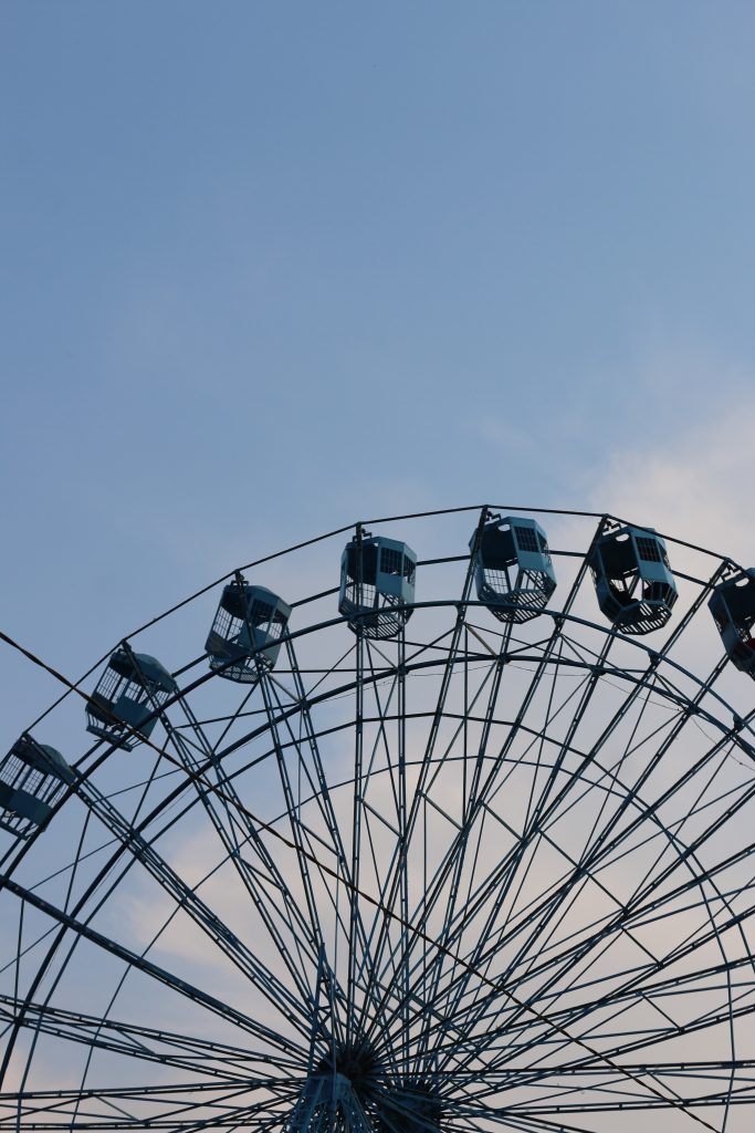 A close-up view of a ferris wheel against a clear blue sky.