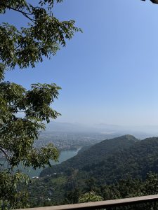 Panoramic view of a tranquil lake in a green valley with mountains in the distance, Pokhara, Nepal.