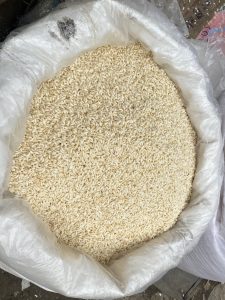 An open bag filled with uncooked short-grain rice, showing pale grains against a white interior.