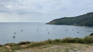 
A serene coastal view featuring multiple boats anchored in a calm sea. 