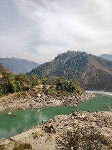 
A serene landscape featuring a winding river with turquoise waters flowing through a rocky bed.