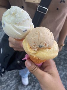 
Two ice cream cones are held by individuals. 