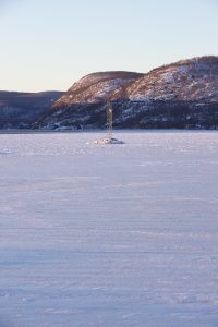 A navigation beacon sits atop a rock pile in the middle of an iced over Peekskill Bay on the Hudson River.
