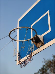 A close-up of a basketball hoop against a clear blue sky. 