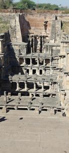 Historic stepwell with detailed carvings and multi-level architecture, showcasing traditional Indian craftsmanship in natural daylight.