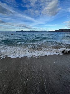 A serene view of a beach where gentle waves meet a sandy shore. 