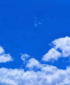 A clear blue sky featuring fluffy white clouds scattered across the horizon. 
