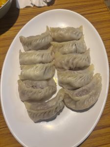 A plate of dumplings arranged neatly on a wooden table, showcasing their golden-brown color and delicate texture.