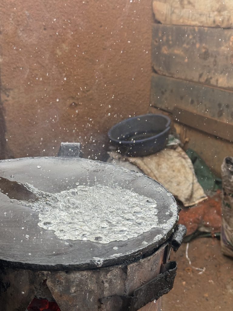 Water poured on a hot frying pan on a charcoal stove.