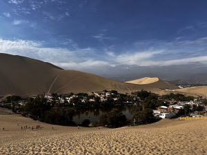 Guaca China Oasis, 5 km south of Ica, Peru, is a stunning desert oasis with emerald waters, palm trees, and tall dunes.