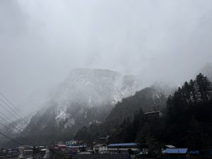 
A foggy mountainous landscape is depicted, with partially obscured peaks shrouded in mist. 