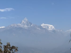 Scenic view of Machhapuchhre (Fishtail Mountain) with its sharp, snow-covered peak surrounded by lower mountains.