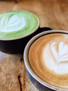 A cup of coffee and matcha side by side