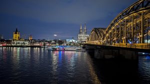 Cityscape at night with river reflections, Colonia, Germany.
