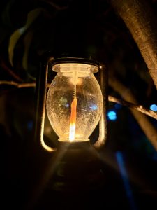A close-up of an antique lantern emitting a warm, flickering light. 