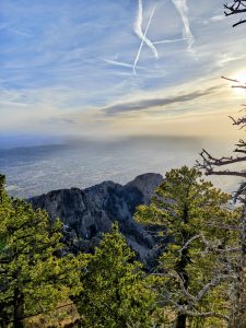 
A panoramic view from a mountain peak showcasing rugged mountain ridges and a valley below. 