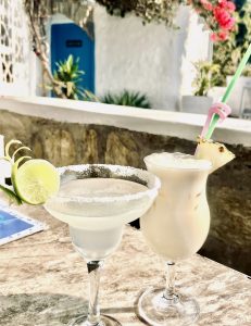 Two drinks sit on a white tablecloth, elegantly arranged on a dining table