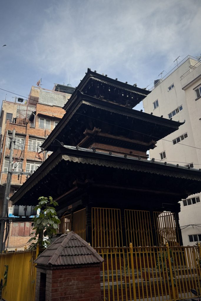A multi-tiered pagoda-style temple made of dark wood with intricate carvings.