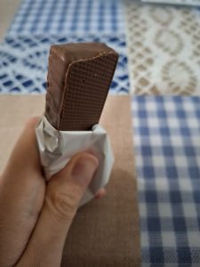 Hand grasping a chocolate bar.