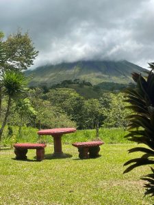 Hay unas bancas y al fondo se logra apreciar el volcán arenal que se ubica en san Carlos – Costa Rica
